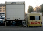 mit 2004 beschrifteter Container neben einem Kastenwagen mit Aufschrift Pirelli
